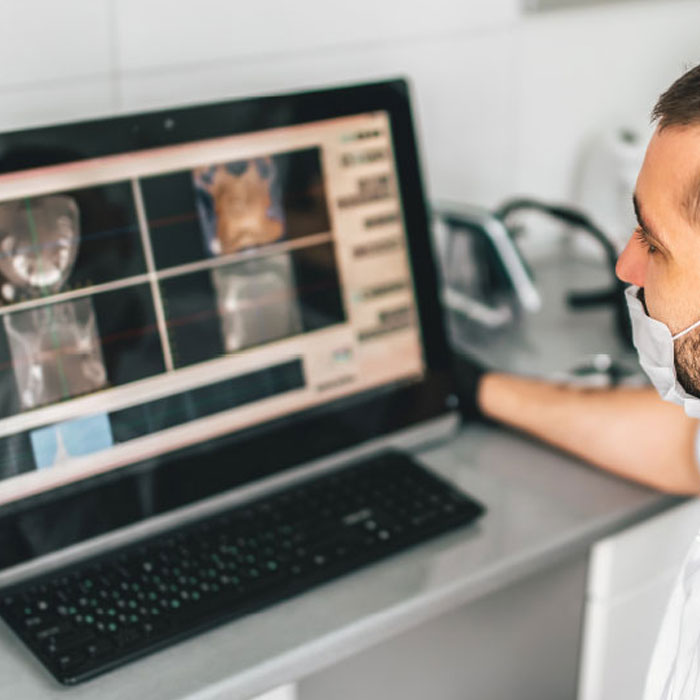 A dental professional using a 3D imaging system for patient diagnosis.
